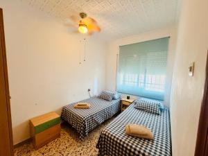 a room with two beds and a window at Cala de Los Lobos in Puerto de Mazarrón