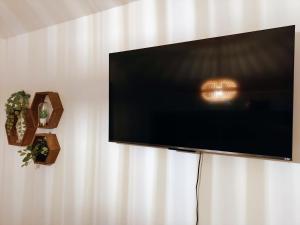 a flat screen tv hanging on a wall at NorthSpot Cabin in Horodnic de Sus