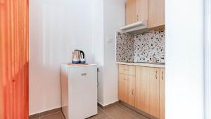 a small kitchen with a white refrigerator and cabinets at Mini Stylish - Central Studio w kitchen in Himare
