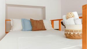 a bedroom with a bed with white sheets and pillows at Mini Stylish - Central Studio w kitchen in Himare +8 photos