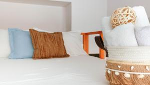 a bed with pillows and a basket on it at Mini Stylish - Central Studio w kitchen in Himare