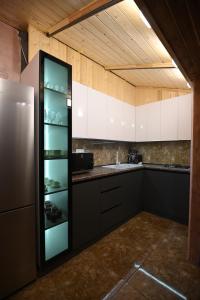 a kitchen with black and white cabinets and a refrigerator at ARBAT house LUXURY in Arbatʼ