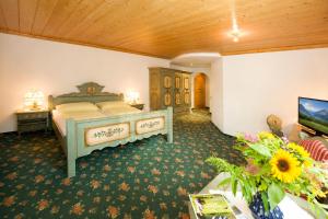 a bedroom with a bed and a tv in a room at Hotel Bräu in Rauris