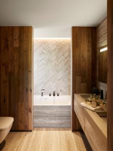 a bathroom with a tub and a toilet and a sink at Les Chalets de l'Observatoire in Megève +26 photos
