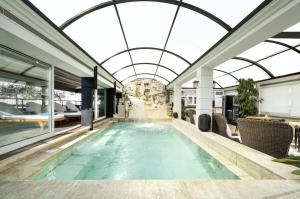 an indoor swimming pool with a glass ceiling at Coral Hotel Athens in Athens