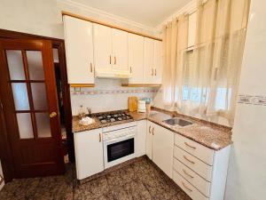 a kitchen with white cabinets and a sink at Cala de Los Lobos in Puerto de Mazarrón