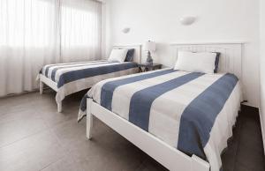 a bedroom with two beds and a window at Sandy Feet House in Puerto Villamil