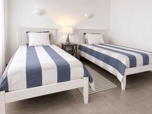 two beds sitting next to each other in a room at Sandy Feet House in Puerto Villamil