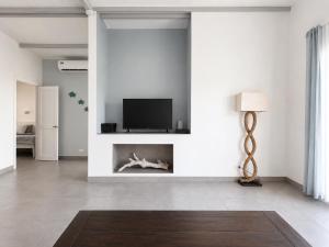 a living room with a tv and a fireplace at Sandy Feet House in Puerto Villamil