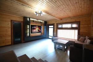 a living room with a couch and a tv at ARBAT house LUXURY in Arbatʼ