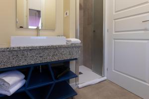 a bathroom with a sink and a mirror and a door at VILLA UGO b & b in Salsomaggiore Terme