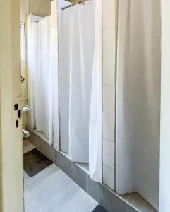 a bathroom with white shower stalls in a room at Crystal Hostels in Livingstone