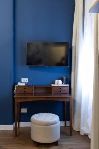 a living room with a tv and a blue wall at VILLA UGO b & b in Salsomaggiore Terme +50 photos