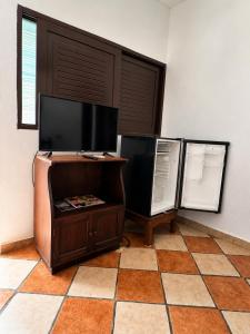 a living room with a tv and a tiled floor at Hotel Valeria in Granada