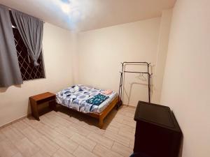a small bedroom with a bed and a television at Estancia 3 in Tena