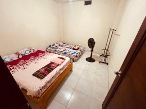 a small bedroom with two beds and a fan at Estancia 3 in Tena