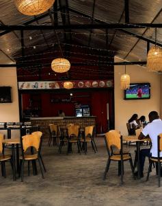a restaurant with tables and chairs and a bar at Crystal Hostels in Livingstone
