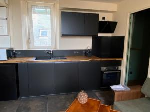 a kitchen with a sink and a counter top at Les Gens Heureux Appartement GLAZ in Paimpol
