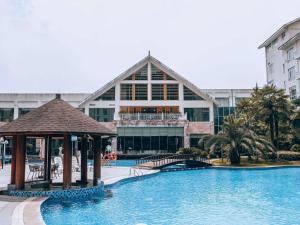a resort with a large swimming pool with a gazebo at Pullman Zhangjiajie Hotel in Zhangjiajie