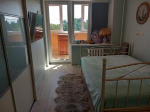 a bedroom with a bed and a desk with a window at Amber Beach Apartment in Narva-Jõesuu