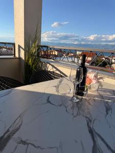 a table with a bottle of wine and a glass at Luxury Blue Sky in Vir