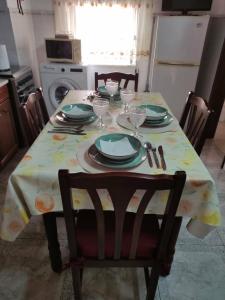 a dining room table with plates and glasses on it at Casa da Cristina in Nazaré