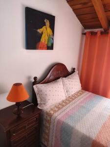 a bedroom with a bed and a painting on the wall at Casa da Cristina in Nazaré