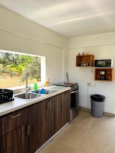 a kitchen with a sink and a stove and a window at Villa Morivivi Couples with pool in Tierras Nuevas Poniente