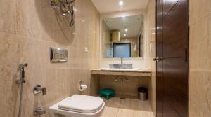 a bathroom with a toilet and a sink and a mirror at The Chapter Hotel, Vasant Kunj in New Delhi +23 photos