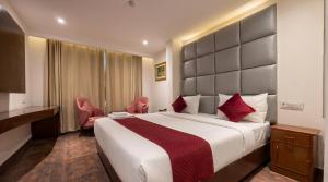 a hotel room with a large bed and two chairs at The Chapter Hotel, Vasant Kunj in New Delhi