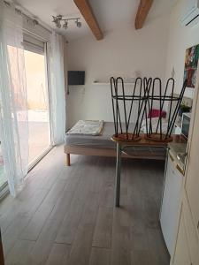 a room with a bed and a kitchen with a window at Studio sympa avec parking privé, piscine et clim in Manosque