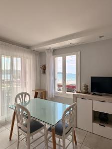 a dining room with a glass table and chairs at Hôtel Valencia in Hendaye