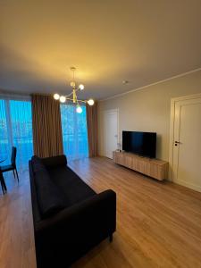 a living room with a couch and a flat screen tv at Cozy corner89, private parking in Valmiera