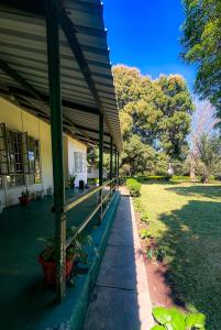 a porch of a building with plants on it at Crystal Hostels in Livingstone