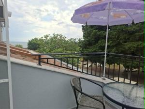 a balcony with a table and an umbrella at Gardenia Guest House in Balchik +42 photos