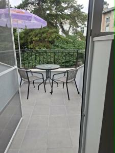 a patio with a table and chairs and an umbrella at Gardenia Guest House in Balchik
