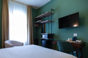 a hotel room with a bed and a desk and a television at VILLA UGO b & b in Salsomaggiore Terme