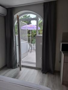 an open door to a patio with an umbrella at Gardenia Guest House in Balchik