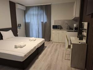 a hotel room with two beds and a kitchen at Gardenia Guest House in Balchik