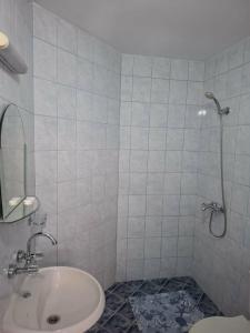 a white bathroom with a sink and a shower at Gardenia Guest House in Balchik