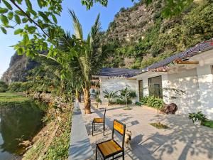 a house on the side of a river with a mountain at Vivian riverside cottage - Ninh Bình in Nguyên Ngoại