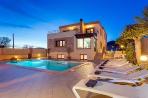 a villa with a swimming pool and lounge chairs at Villa Campo Sol in Ibiza Town