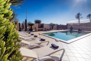 a row of lounge chairs next to a swimming pool at Villa Campo Sol in Ibiza Town