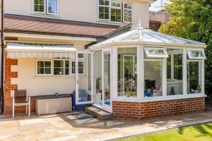 a conservatory with glass doors on a house at Leafy Suburban Bed and Breakfast in Northwood