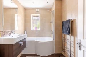 a bathroom with a tub and a sink and a shower at Leafy Suburban Bed and Breakfast in Northwood