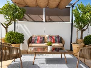 a couch on a patio with two chairs and a table at Casa Romana Hotel Boutique in Seville