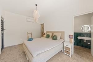 a bedroom with a white bed and a sink at Luxe Tropische Villa met Privézwembad in Jan Thiel +25 photos