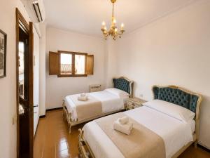 a hotel room with two beds and a chandelier at Sa Torre - Casa Mallorquina con encanto in Campos