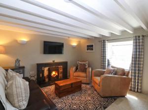 a living room with a couch and a fireplace at 4 Bryn Llan in Pwllheli