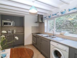 a kitchen with a washing machine and a window at 4 Bryn Llan in Pwllheli